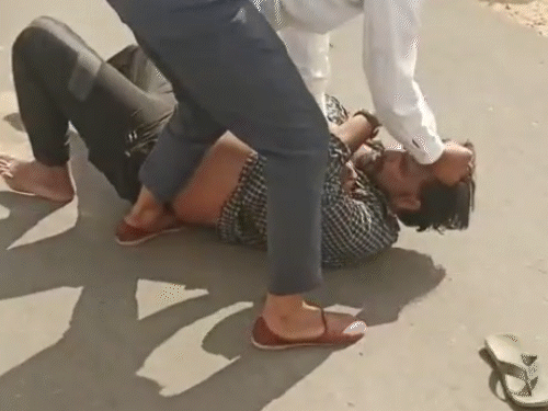 एक युवक हिस्ट्रीशीटर को सड़क पर पटक कर उसके बाल पकड़ कर और लोगों के आने का इंतजार करता रहा।