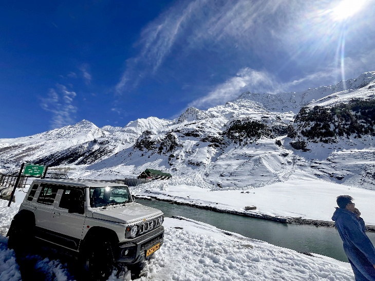 हिमाचल में अटल टनल के नॉर्थ पोर्टल के पास बर्फ से ढके इलाके में लोग अभी भी रास्ता साफ होने का इंतजार कर रहे हैं।