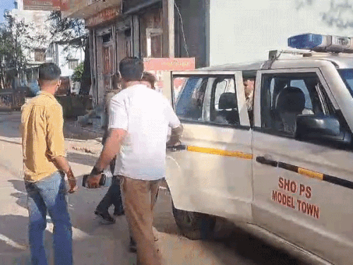 होटल मैनेजर को ले जाती पुलिस टीम।