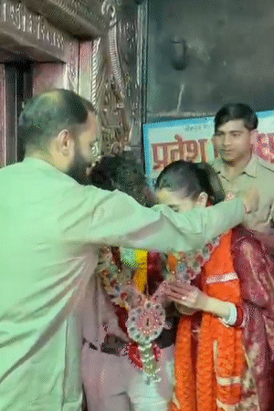 पुजारी ने कुलदीप और उनकी पत्नी को भगवान की प्रसादी माला भेंट की।