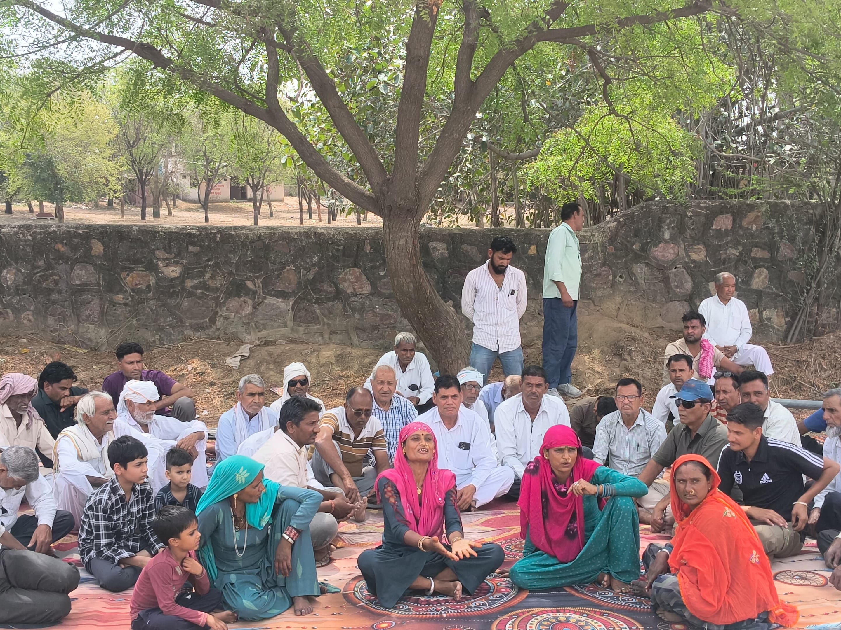 प्रदर्शन के दौरान टंकी के नीचे बैठे लोग।