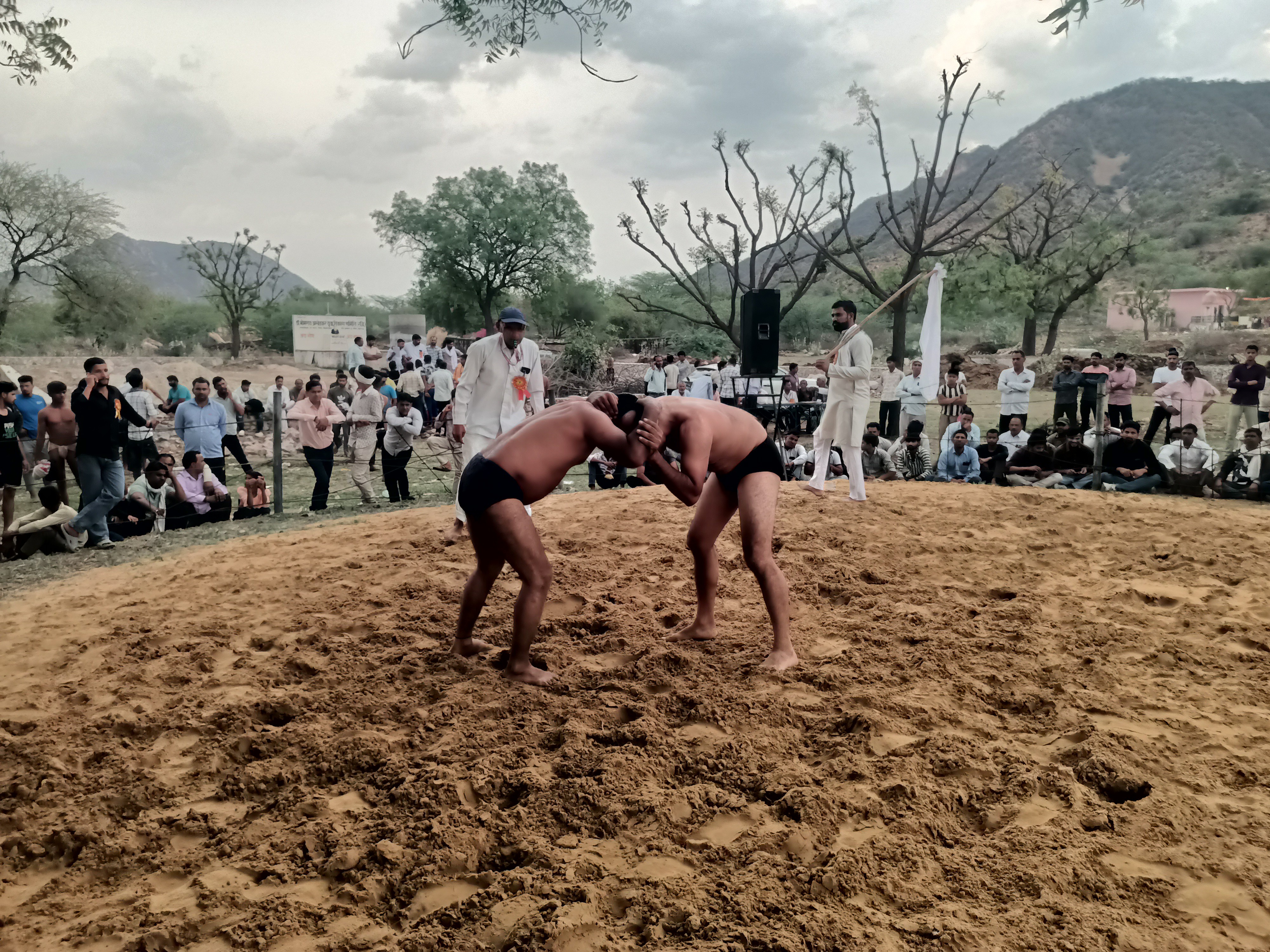दूर-दराज से आए पहलवानों ने कुश्ती दंगल में भाग लिया।