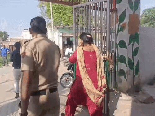 नकल कराने की आरोपी टीचर टीम के सामने ही मुंह छिपाकर स्कूल से बाहर निकल गई।