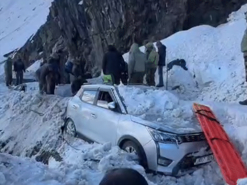 एवलांच शुक्रवार शाम 4 बजे आया। कार पर जमीं बर्फ हटाते लोग।