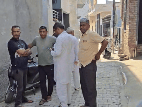 मृतक के घर के बाहर खड़े परिजन।