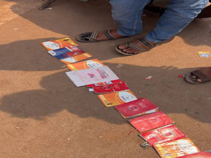 सिलेंडर कार्ड को जमीन पर रखकर अपने नंबर का इंतजार करते लोग।