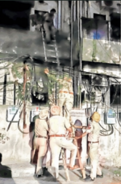 कैद हुए कर्मियों को सीढ़ी के सहारे बाहर निकालते पुलिसकर्मी।