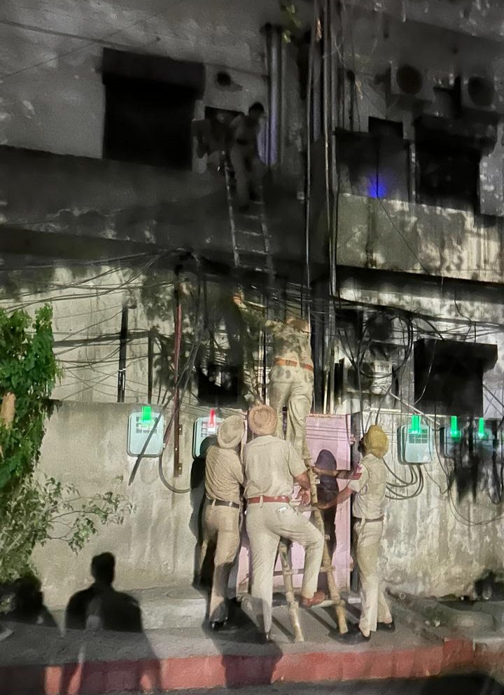 कैद हुए कर्मियों को सीढ़ी के सहारे बाहर निकालते पुलिसकर्मी।