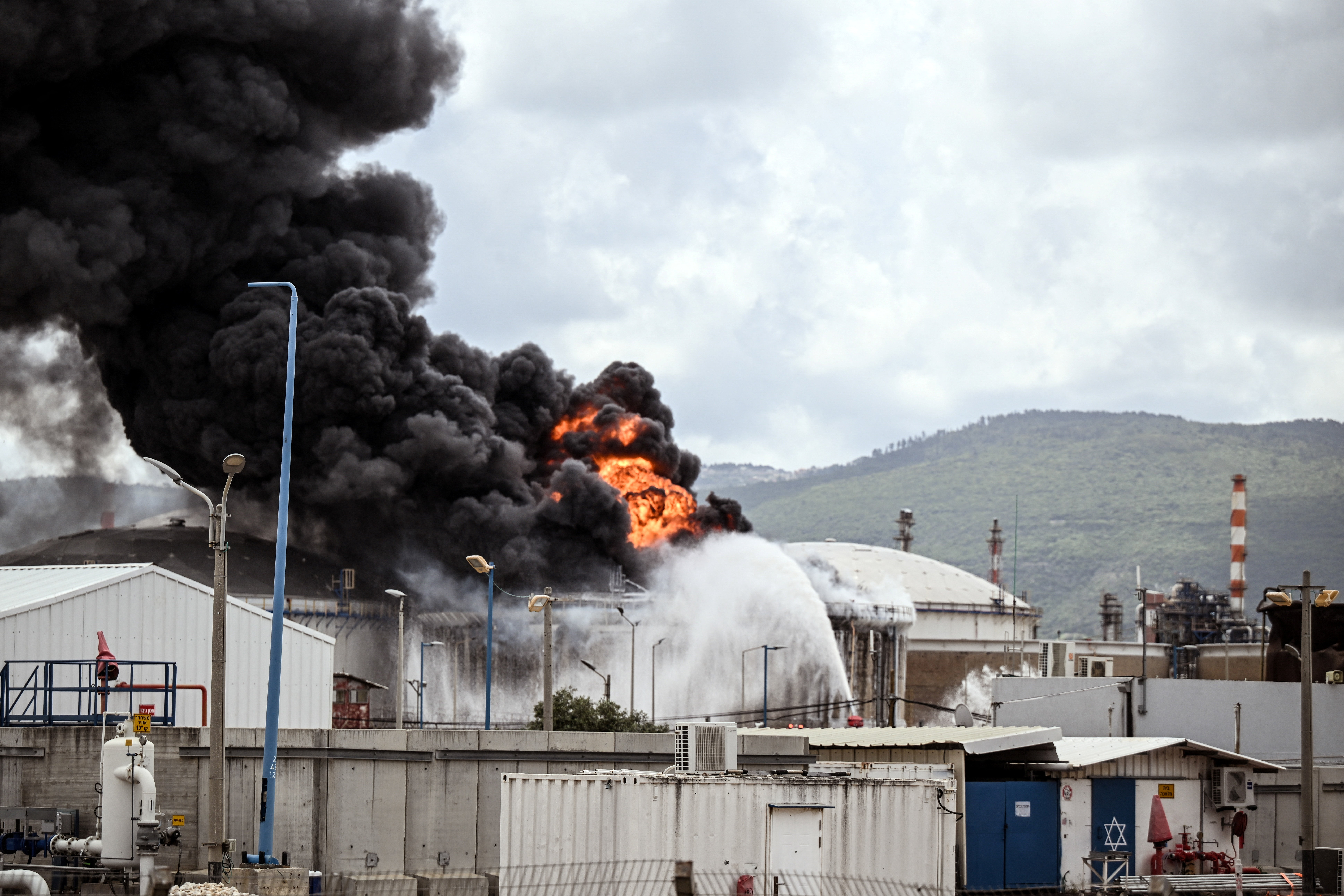 इजराइल के हाइफा शहर में सोमवार को हिजबुल्लाह की तरफ से दागी गई एक ईरानी मिसाइल अटैक के बाद ऑयल रिफाइनरी में आग लग गई।