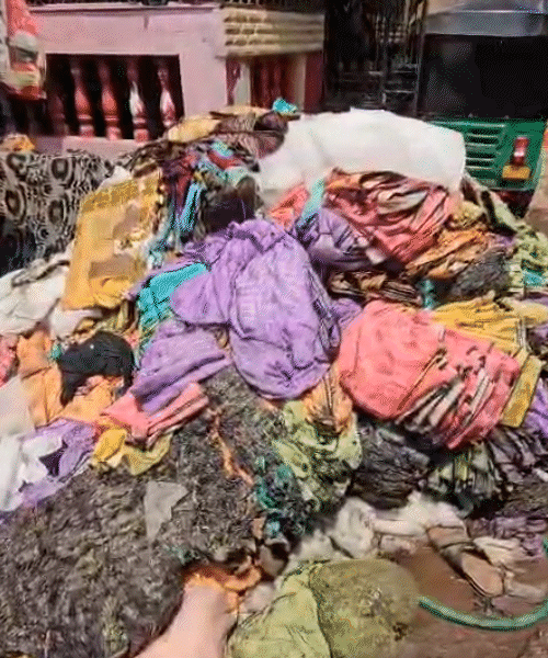 घर के बाहर जली हुई साड़ियों का ढेर।