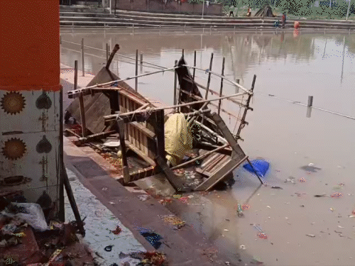 भगदड़ के बाद मंदिर के पास के तालाब में पूजा सामग्री की दुकानों के सामान गिरे पड़े हैं।