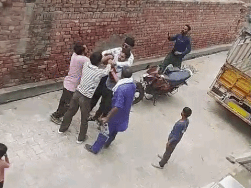 आसपास के लोग युवक से पिस्टल छीनने की कोशिश करते हुए।