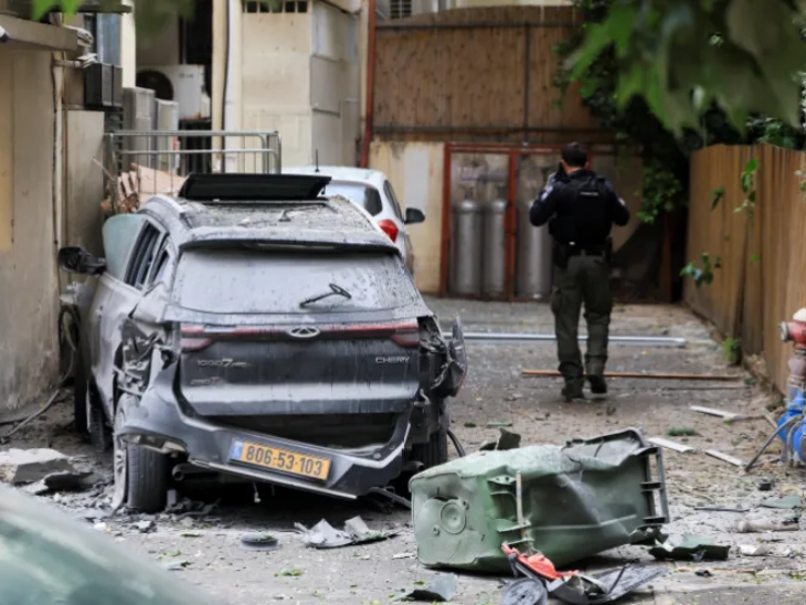 इजराइली पुलिसकर्मियों ने तेल अवीव में ईरान के मिसाइल हमले में क्षतिग्रस्त हुई कार के पास जांच की।