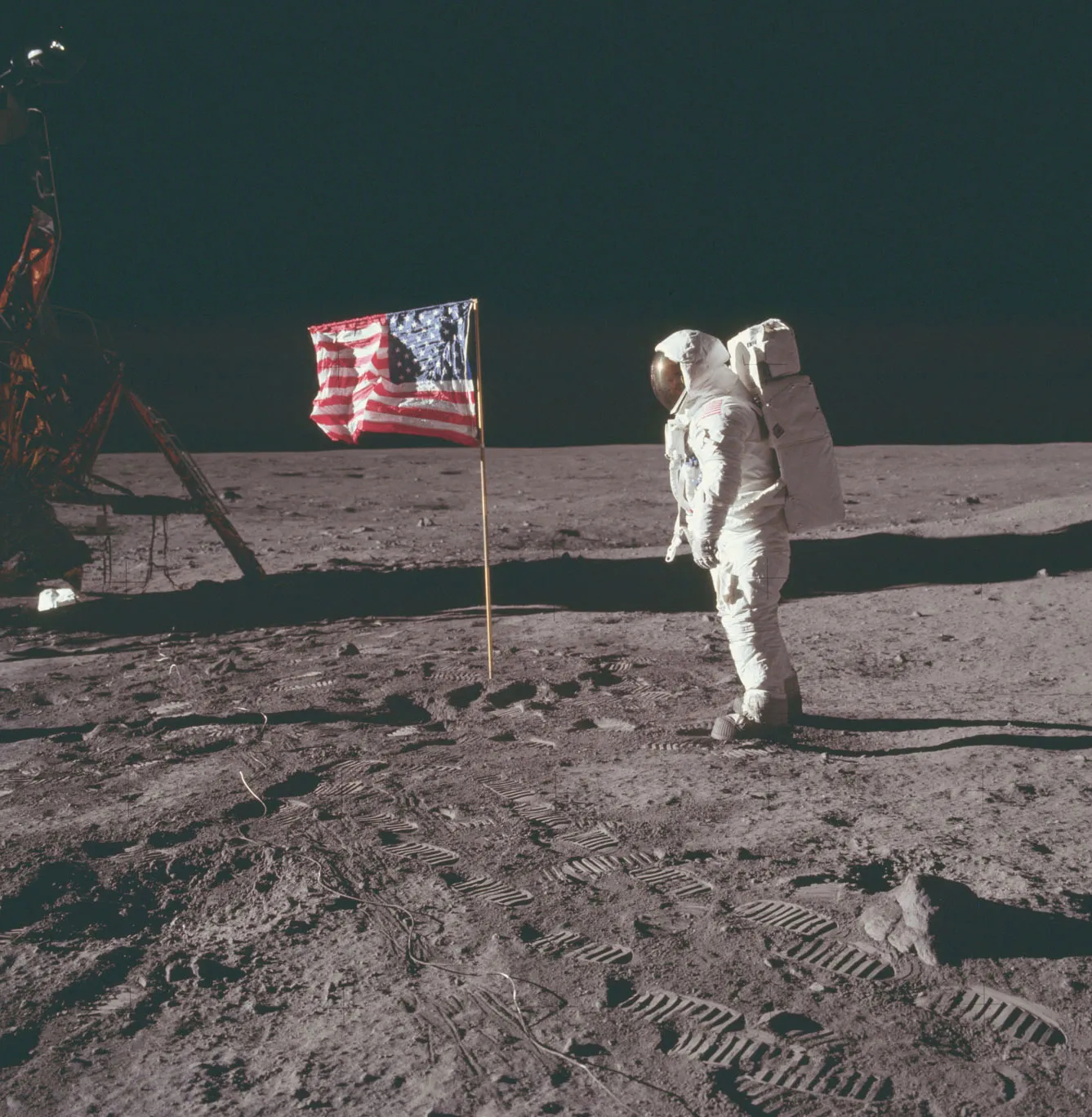 Astronaut Buzz Aldrin standing near the American flag on the surface of the Moon in 1969.