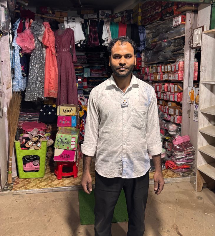 घर टूटने के बाद से अफसर अली की दुकान के एक हिस्से में उनका परिवार रहता है। दूसरे हिस्से में वे कपड़े बेचते हैं।