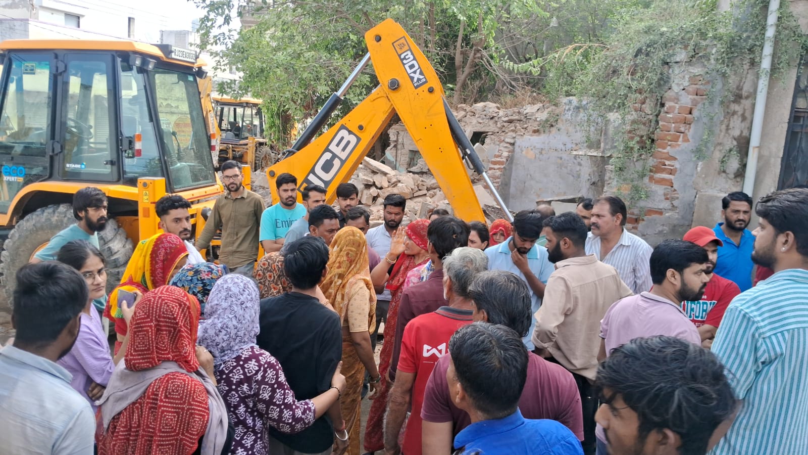 मकान तोड़ने का विरोध करते हुए स्थानीय लोग।
