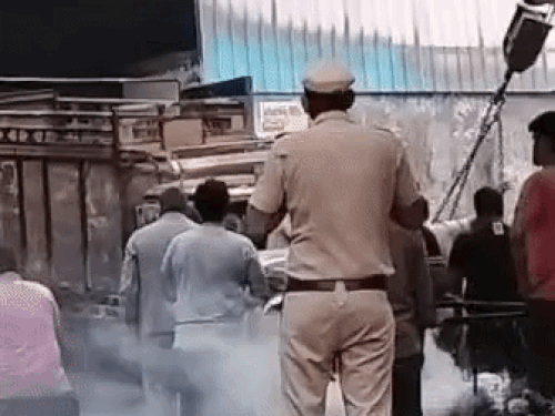 मौके पर पहुंची पुलिस जले हुए सामान को बाहर निकालते हुए।