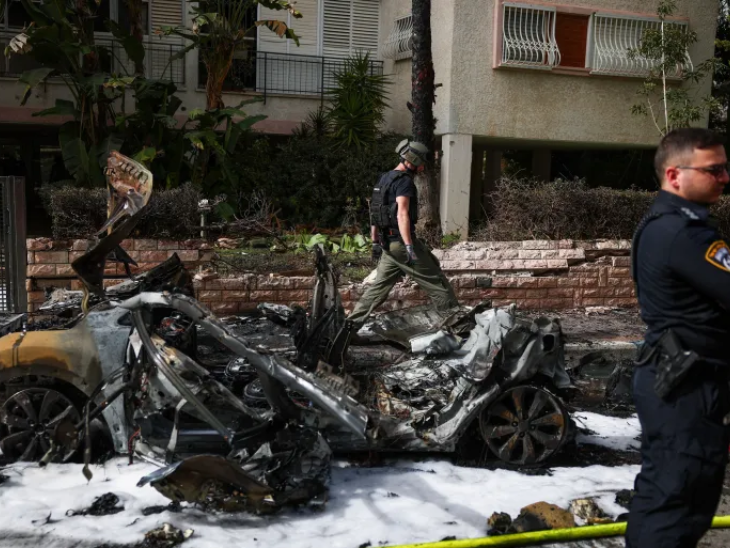 ईरान के मिसाइल हमले के बाद सेंट्रल इजराइल में एक कार पूरी तरह जल गई।