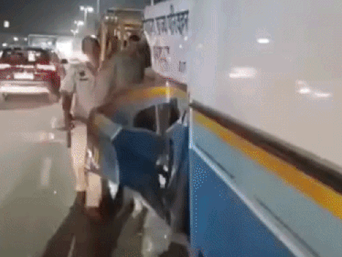 बस के टूटे हुए हिस्से को एक साइड में करते पुलिसकर्मी।