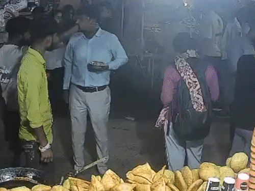 विकास( सफेद शर्ट में) अपनी पत्नी के साथ खड़ा होकर कचौरी खा रहा था, दुकानदार ने उन्हें दूर जाने को कहा।