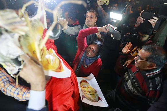 विरोध प्रदर्शन के दौरान केरल के सीएम पिनाराई विजयन के पोस्टर को चप्पल मारती महिला।