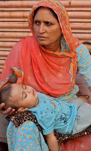 जयपुर के गंगा पोल स्थित परीक्षा केंद्र के बाहर 10 महीने के पोते को संभालती महिला। उनकी बहू परीक्षा देने गई थी।