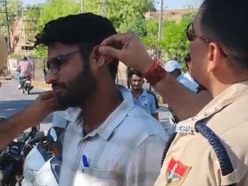 नागौर के रतन बेन सीनियर सेकेंडरी स्कूल में अभ्यर्थियों के कानों की जांच करते पुलिसकर्मी।
