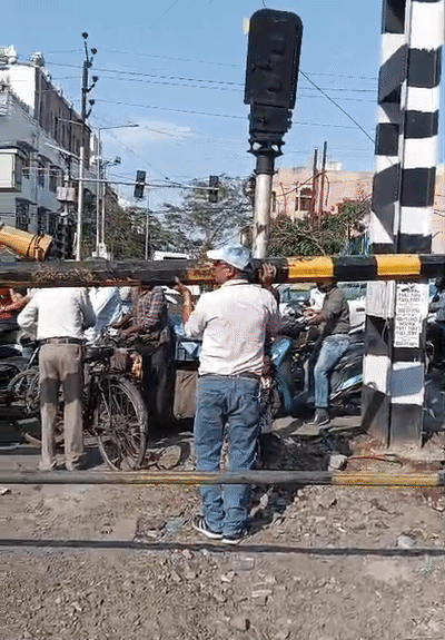 बैरियर मरम्मत का काम करते रेलवे कर्मचारी