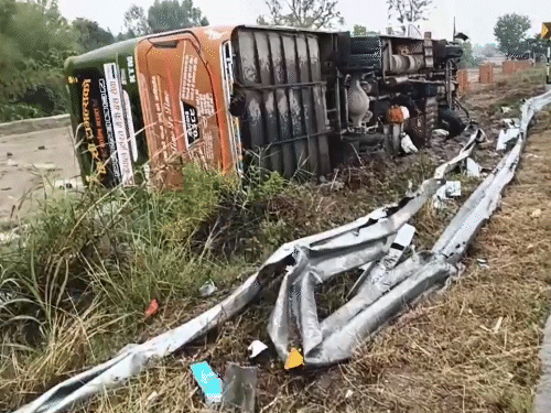 सेफ्टी बैरियर को तोड़ते हुए पलटी बस।