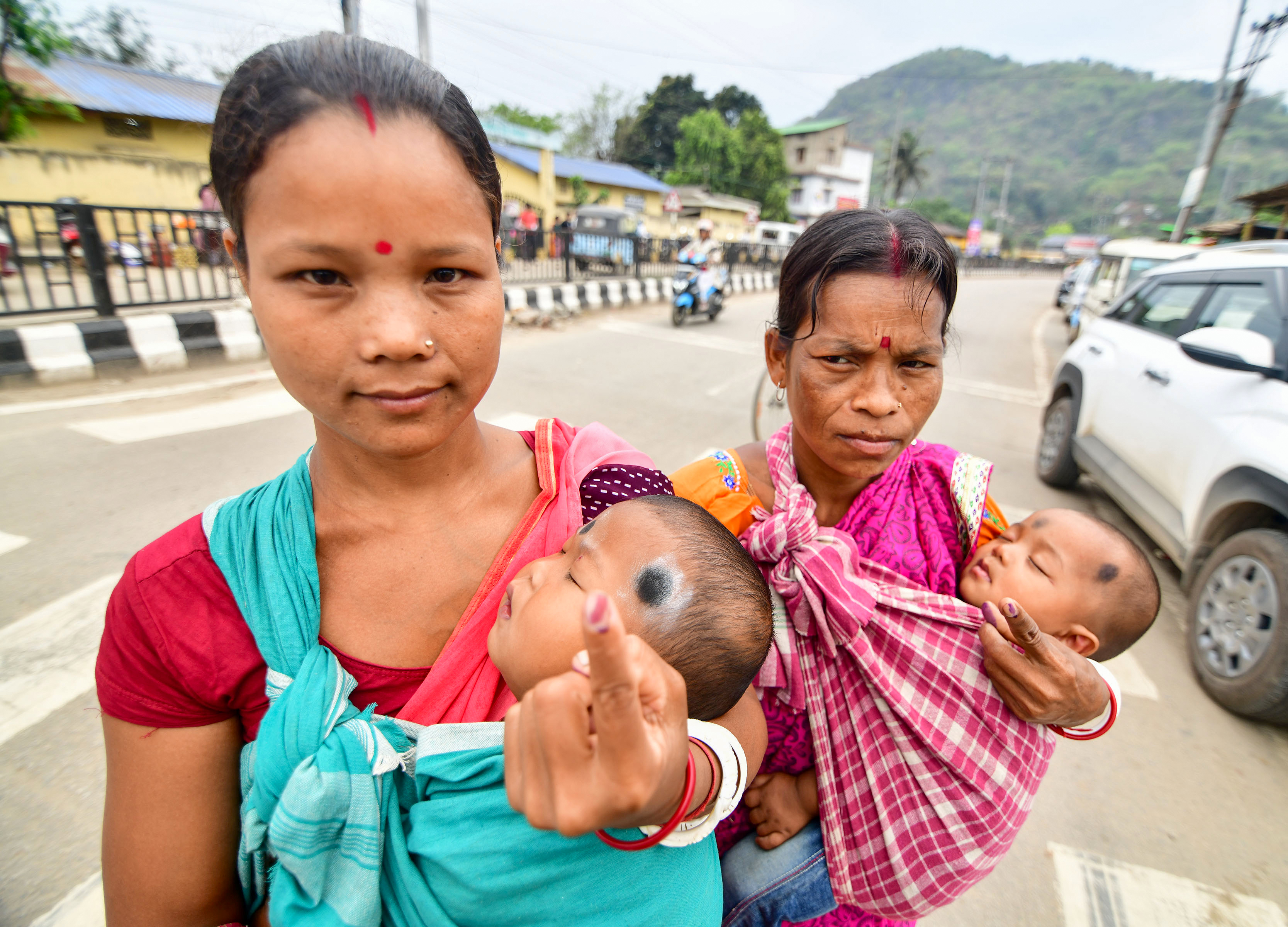 असम में वोट डालने के लिए महिलाएं अपने छोटे बच्चों को साथ में लेकर आईं। उन्हें कपड़े के सहारे कंधे से टांगा हुआ था।