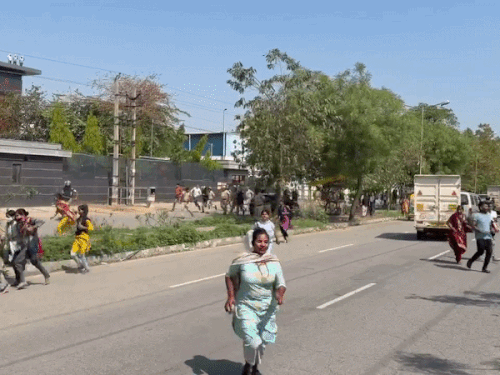 Female employees running after being lathi-charged by police.