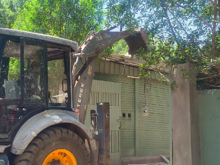 जेसीबी की मदद से बाउंड्रीवॉल तोड़ने की कार्रवाई शुरू की गई।