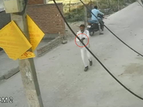 गोली मारने के बाद हमलावर भागकर बाइक के पास पहुंचता है। तमंचे को छिपाने की कोशिश करता है।