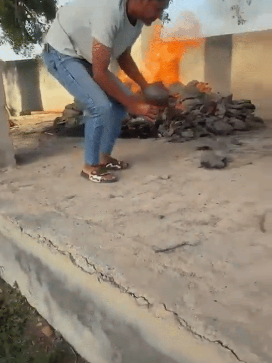 चिता से आग निकालने के बाद युवक ने उसे हुक्के में भरा।