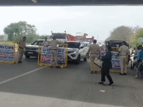 रोहतक में मकड़ौली टोल से पहले गाड़ियों को रोकते हुए पुलिसकर्मी।