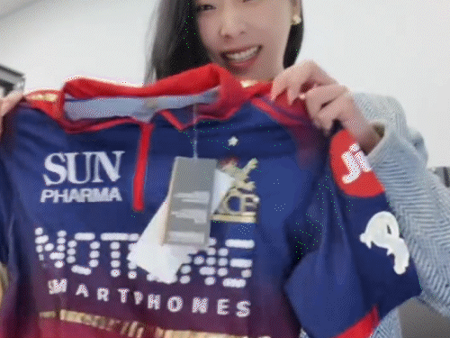 मिशेल RCB की जर्सी अनबॉक्स करती हुईं।