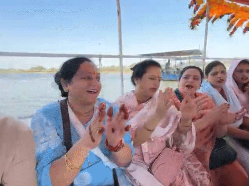 नाव में बैठे श्रद्धालु भजन-कीर्तन करते दिखाई दिए।