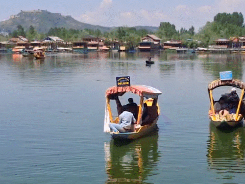 जम्मू-कश्मीर की कश्मीर घाटी में मौसम में सुधार होने के बाद डल झील पर पर्यटक नजर आए।