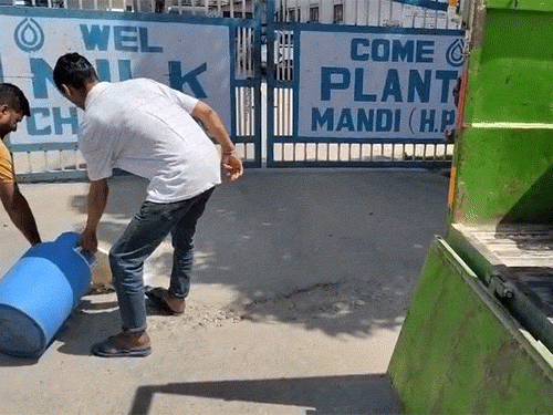 मंडी के चक्कर प्लांट के बाहर दूध बहाते हुए किसान।