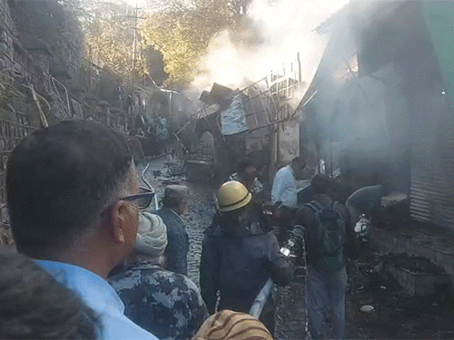 कसौली मार्केट में आग पर काबू पाते हुए दमकल कर्मी।