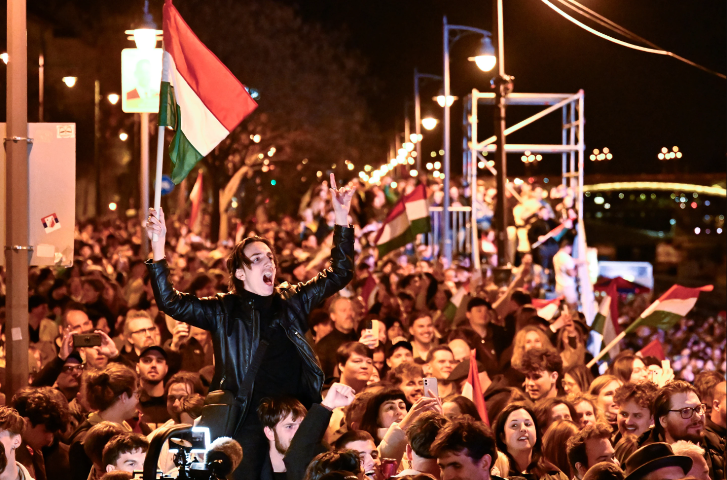 A man waves a Hungarian flag as he celebrates in the street, following the announcement of partial results of Hungary's parliamentary elections, in Budapest.