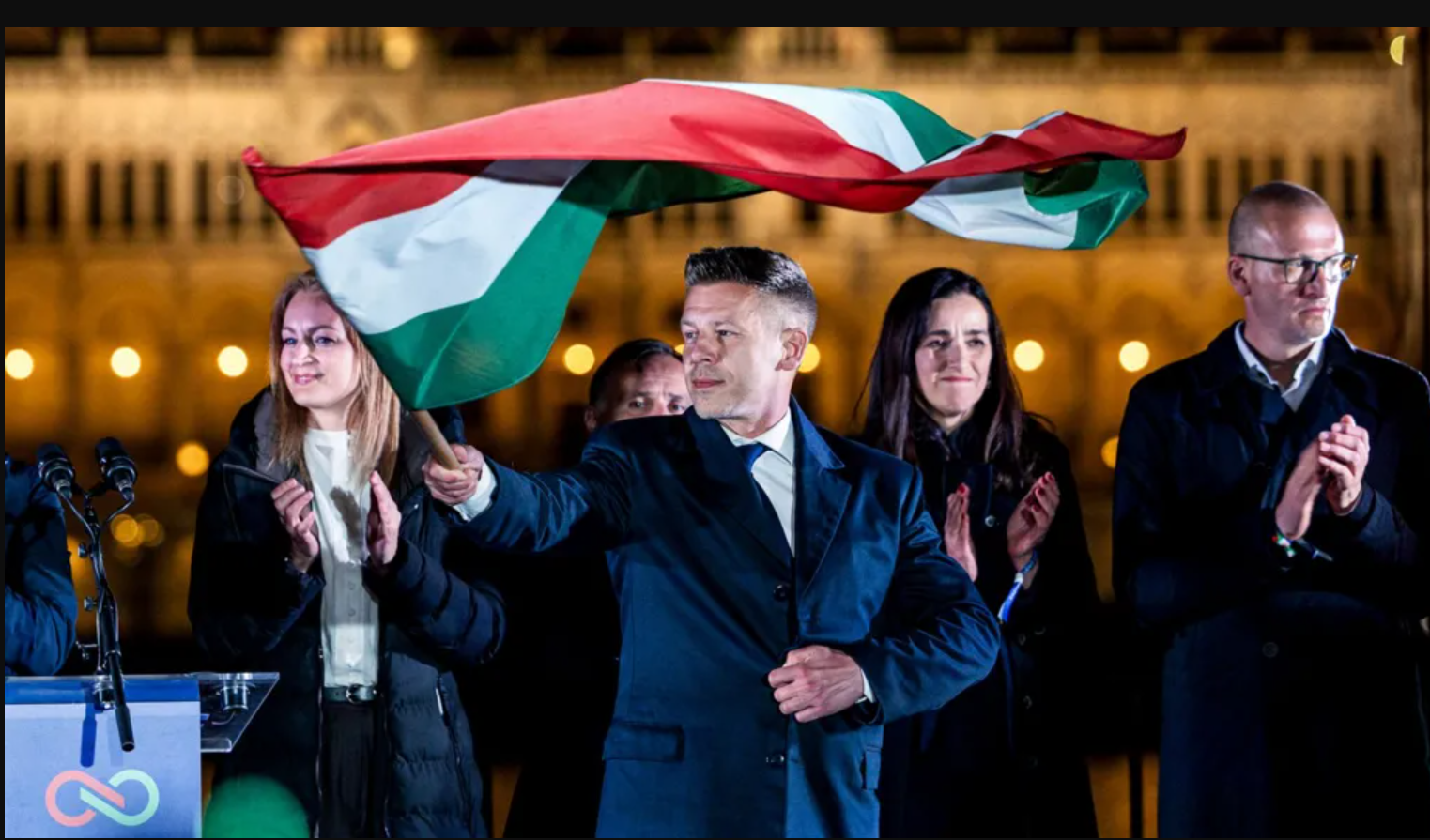 Peter Magyar waves the Hungarian flag celebrating his victory late at night in Budapest.