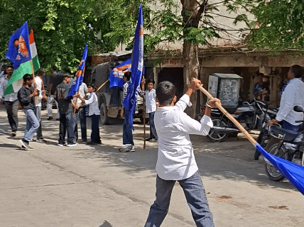 हाथों में झंडा लेकर करतब दिखाते हुए युवक।