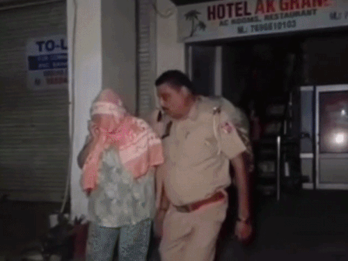 पुलिस की टीमें महिलाओं को काबू कर ले जाती हुई।