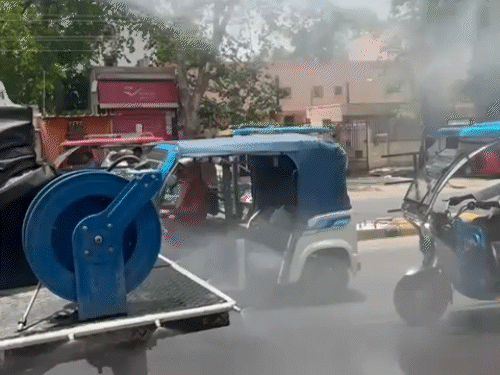 दोपहर के समय गर्मी थामने के लिए सड़कों पर पानी का छिड़काव किया जा रहा है।