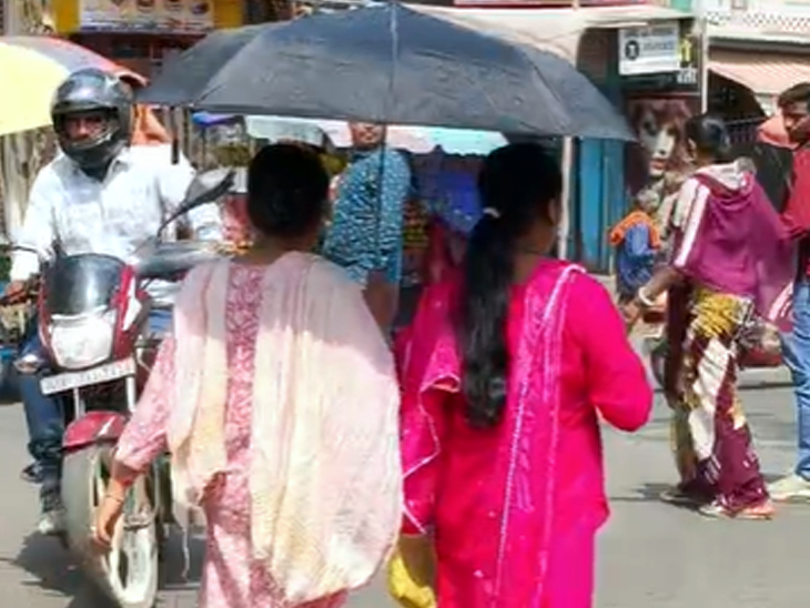 गिरिडीह में तेज धूप से बचने के लिए लोग छाता लेकर सड़क पर निकल रहे हैं।