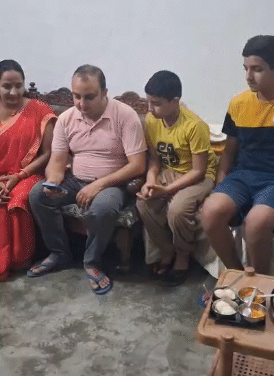 परिवार के साथ मोबाइल पर दैनिक भास्कर एप देखते चंदन।