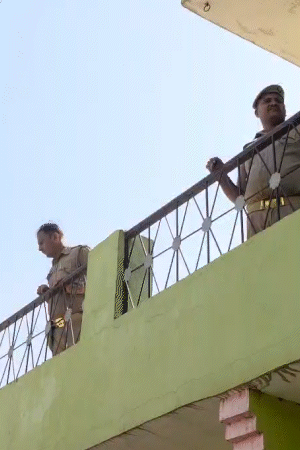 बिछोली गांव में बुलडोजर कार्रवाई वाली जगह पर सुरक्षा के कड़े इंतजाम किए गए हैं। पुलिसवाले आसपास के घरों की छत से निगरानी कर रहे हैं।