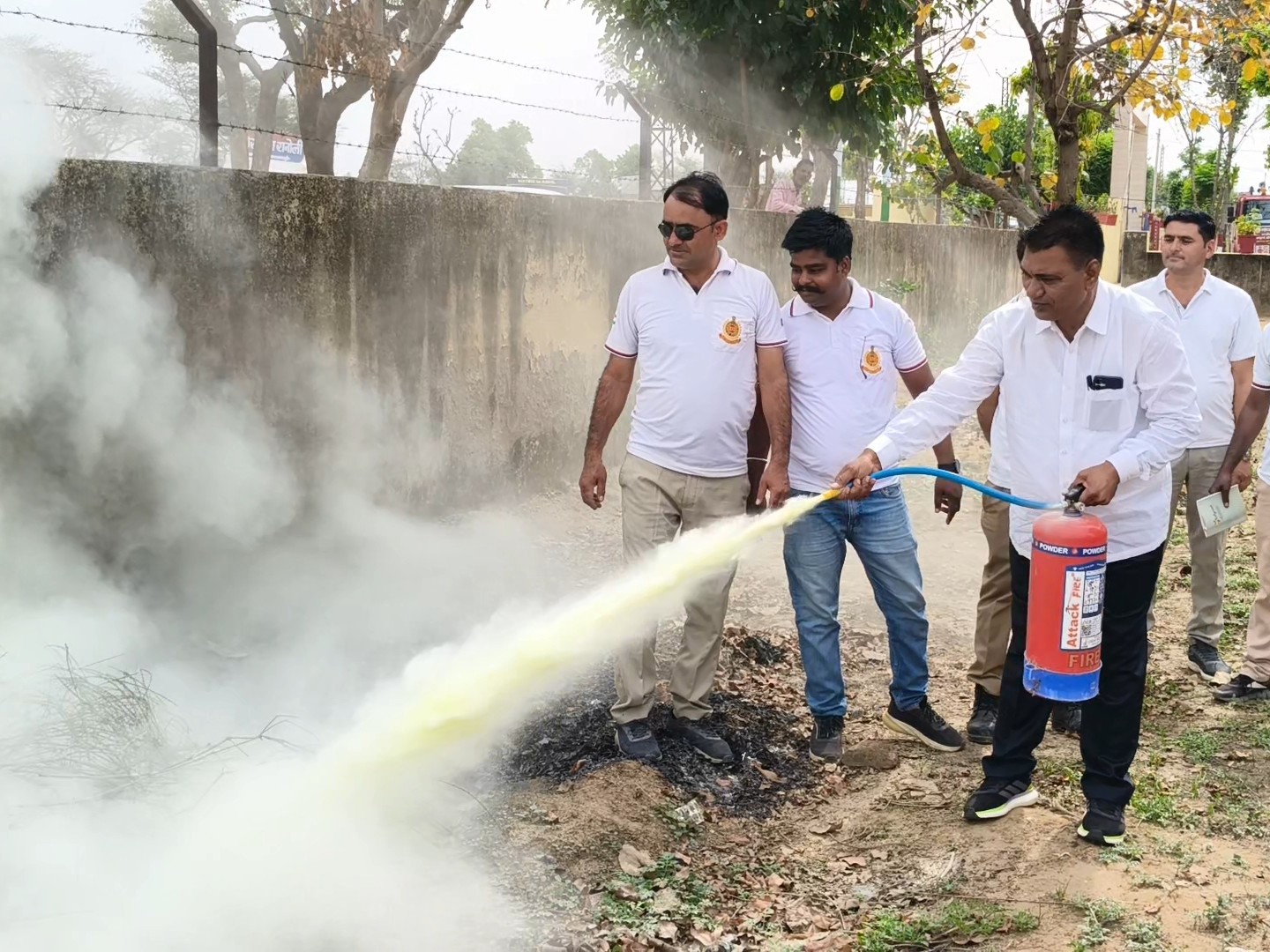 अग्निशमन उपकरण से आग बुझाने का डेमो देते फायरमैन