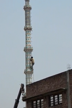 एक मजदूर मीनार पर चढ़कर रस्सी को बांधा, फिर उसके दूसरे सिरे को दोनों हाइड्रा मशीनों से बांधा।